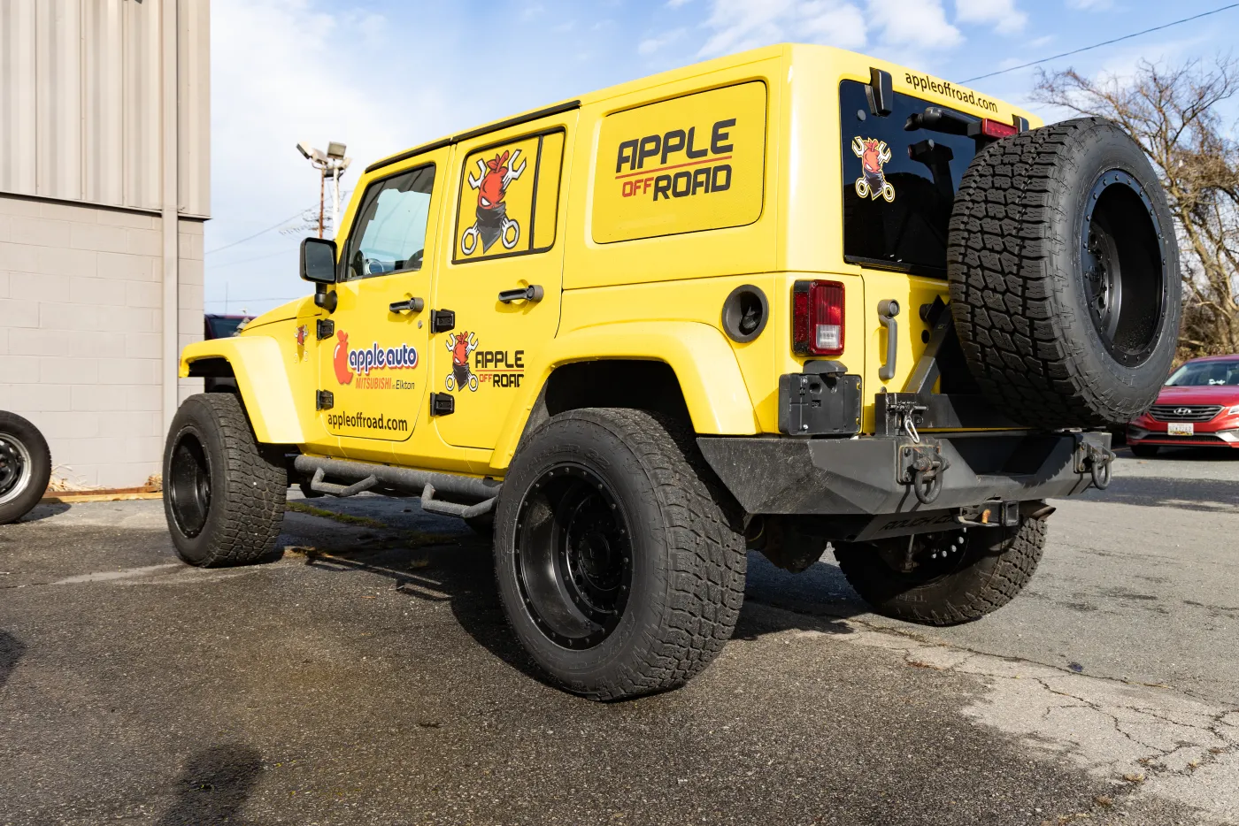 The branded Apple Off Road shop Jeep, lifted on black wheels.