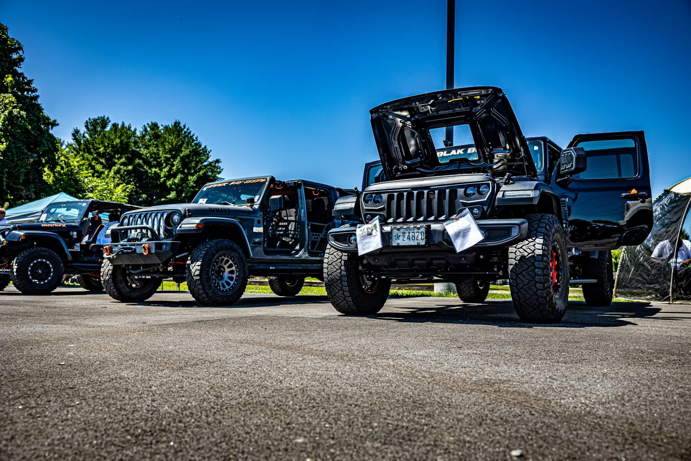 Rows of lifted Jeeps and trucks lined up at the Apple Off Road Truck & Jeep Show.